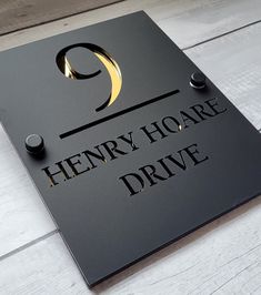 a sign that says henry hoare drive on the side of a wooden floored wall