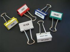 four different colored paper clips with the words pay now written on one side and two small ones attached to each other