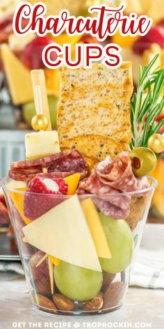 a glass bowl filled with different types of cheeses and crackers on top of a table