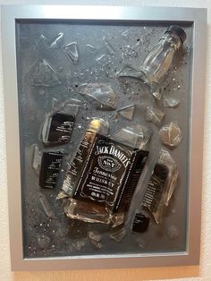 some bottles and ice cubes are on the table in front of a wall hanging