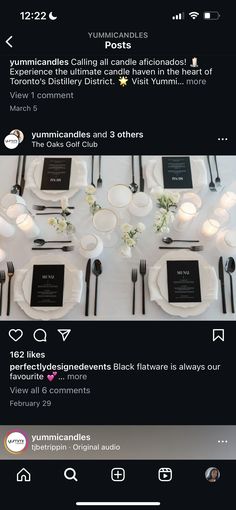 the table is set with black and white plates, silverware, and napkins