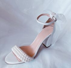 Introducing our exquisite and comfortable wedding sandals, meticulously crafted with the elegant bride in mind. Handmade with utmost care and attention to detail, these wedding pearl heels are the epitome of grace and sophistication. Our Wedding Shoes are designed to capture the essence of romance and enchantment. The delicate organza bow, adds a touch of ethereal charm to these ivory pearl block heels. These comfort shoes are specifically created to ensure that you can dance the night away with ease and grace on your special day. The block heel provides stability and support, allowing you to confidently navigate any terrain. The soft leather lining adds a luxurious feel, pampering your feet with each step you take. Key Features: *Made to order *Elegant and timeless design *Handcrafted wit Sandals For Bride, Pearl Heels, Organza Bow, Pearl Sandals, Bridesmaid Shoes, Elegant Bride, Wedding Sandals, Womens Wedding Shoes, Ivory Pearl