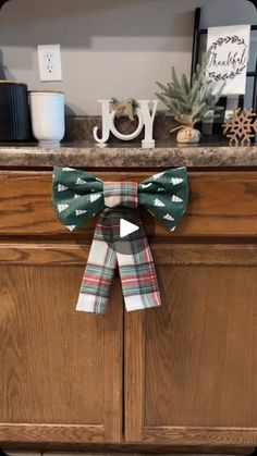 a christmas bow on top of a wooden cabinet