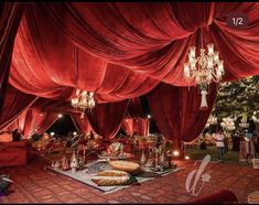 a room filled with lots of red drapes and chandeliers