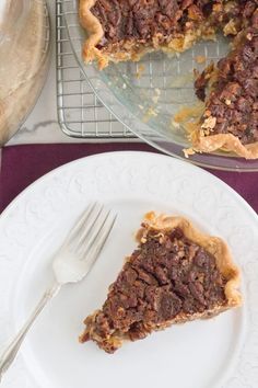 a piece of pie sitting on top of a white plate next to a cake pan