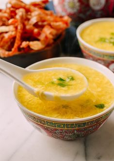 two bowls filled with soup sitting on top of a table