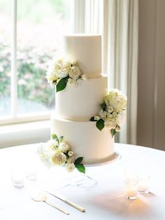 a white wedding cake with flowers on it