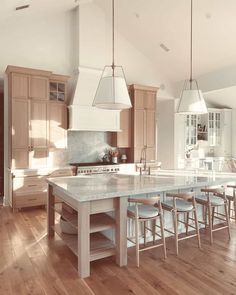 a large kitchen with an island in the middle and lots of counter space on one side