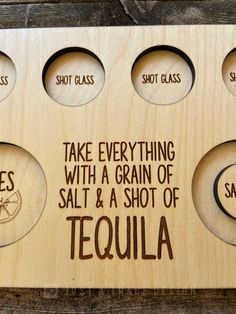 a wooden plaque that says take everything with a grain of salt and a shot of tequila