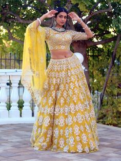 Go all out in this whimsical lehenga, studded with precious mirror, pearl, stone, embroidery work, which is sure to bring out the innate grace and grandeur in you! Color - Chrome Yellow Fabric & Work Style - - Silk blouse: mirror, pearl, stone, embroidery work. - Soft net lehenga: mirror, pearl, stone, embroidery work. - Soft net dupatta: embroidery work. Details - - Assured quality - Wash care instruction: Dry clean only. - Slight variation in color is possible due to digital photography.