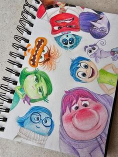 a spiral notebook with cartoon characters drawn on it and colored pencils in the pages