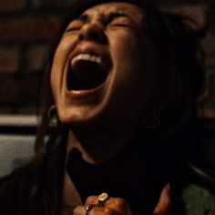 a woman with her mouth open and hands in the air