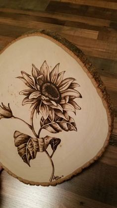 a wooden slice with a sunflower painted on it