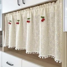 a kitchen window curtain with cherries on it