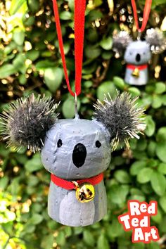 two ornaments made to look like koalas hanging from a red ribbon with the words red ted art on it