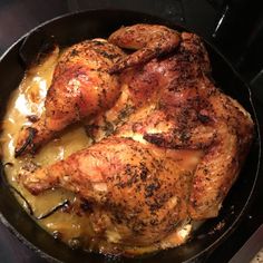 a close up of a chicken in a pan on a stove top with gravy