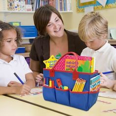 a woman and two children sitting at a table with a blue bag filled with books