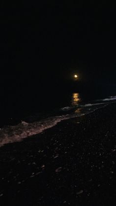 two people walking on the beach at night