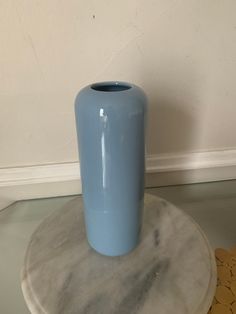 a blue vase sitting on top of a marble table