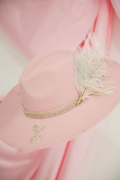 Add a touch of glamour to any outfit with this light pink rancher hat. Featuring silver rhinestone bow patches and a band, as well as a white feather combo with a touch of silver glitter. Take a bow in style with this unique and playful accessory. This hat is ONE OF A KIND, created by our owner Stephanie. To receive item quicker, expedited shipping is available at checkout. Pink Fedora With Flat Brim For Party, Pink Fedora For Party, Pink Flat Brim Fedora For Party, Pink Fedora For Kentucky Derby Party, Rancher Hat, White Feather, Pink Feathers, Rhinestone Bow, White Feathers