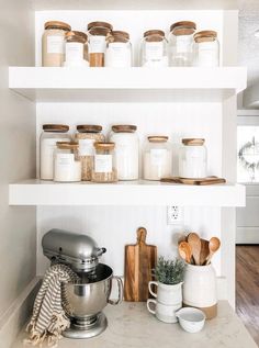 kitchen shelves with jars and utensils on them