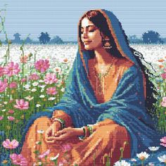 a woman sitting in a field with flowers holding a small dog and wearing a blue shawl