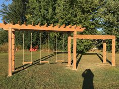 a wooden swing set in the middle of a field