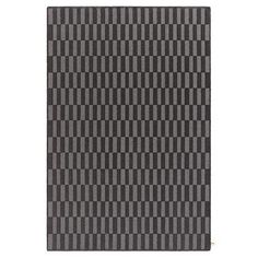 a black and grey rug with vertical lines on it, in the shape of squares