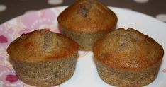 three muffins sitting on top of a pink and white plate