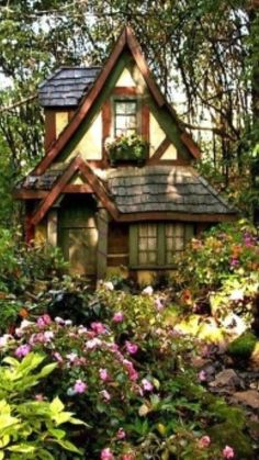 a small house surrounded by flowers and trees