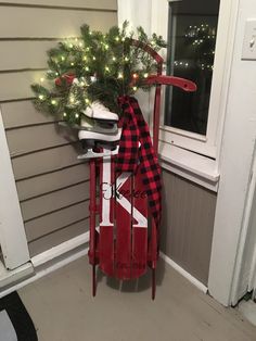 a red sled with white shoes and a christmas tree in it on the front porch