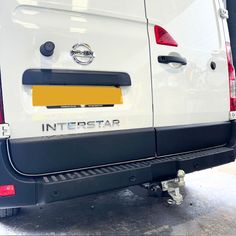 the rear end of a white van with an interstar logo on it's bumper