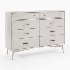 a white dresser with six drawers and two handles on each drawer, in front of a white background