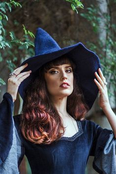 a woman with red hair wearing a witches hat