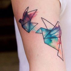 a woman's arm with an origami tattoo on it