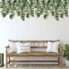 a wooden bench sitting in front of a wall with some green leaves hanging from it