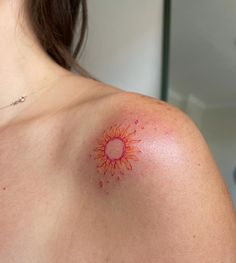 a woman with a sun tattoo on her shoulder