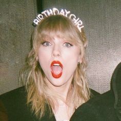 a woman wearing a birthday hat with the words happy birthday written on it's forehead