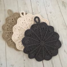 three crocheted doily sitting on top of a white wooden floor next to each other