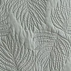 a close up view of a quilted surface with many lines and curves on it