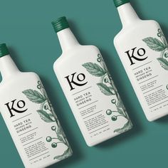 three bottles of ko tea on a green background