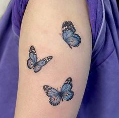 three blue butterflies on the arm