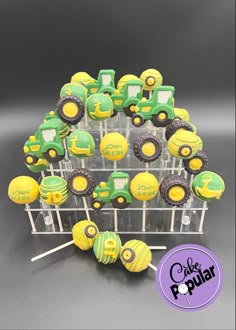 there are many green and yellow cupcakes on the stick in front of each other