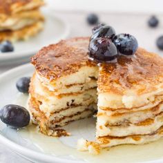 pancakes with blueberries and syrup on white plates