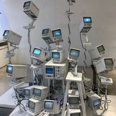 a bunch of old tvs are stacked on top of each other in the middle of a room