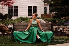 a woman in a green dress sitting on a bench