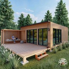 a person sitting on a wooden deck in front of a small house with windows and doors