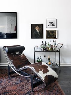 a living room with a chaise lounge chair and pictures on the wall above it