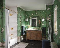 a bathroom with green walls and floral wallpaper