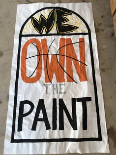 a sign that says own the paint on it with an orange and black basketball ball